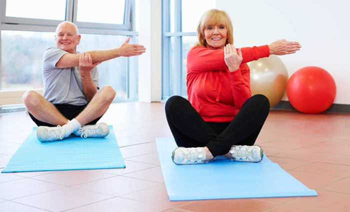 VivaMotion coach exercising together with two older adults in a seated mobility class